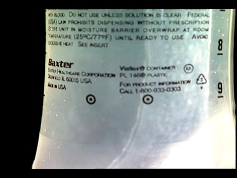 一个点滴管挂在一个装盐水的医疗袋上。视频下载
