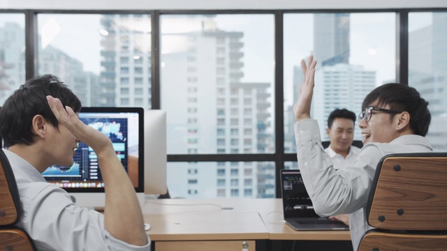 4K UHD:两个亚洲商人官员感到高兴和手碰撞在现代办公室。视频素材