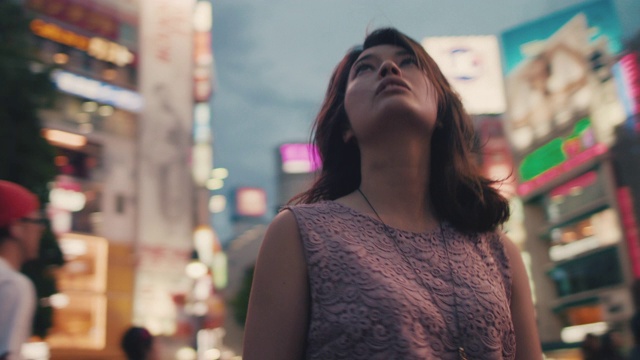 日本东京，一名日本妇女站在繁忙的十字路口跑步视频下载