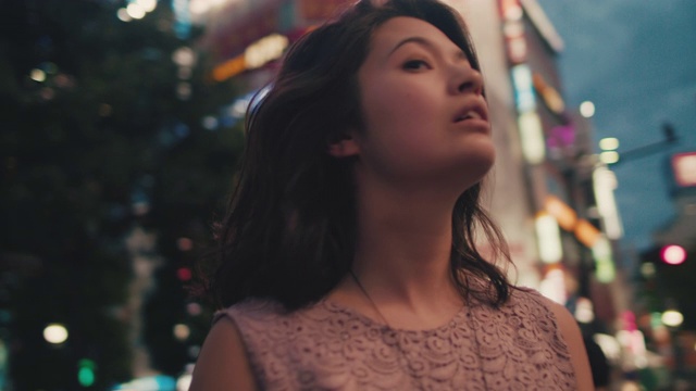旋转镜头的日本女人在城市晚上/东京，日本视频购买