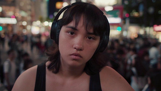 日本东京，一个晚上戴着耳机的年轻日本女人的肖像视频素材