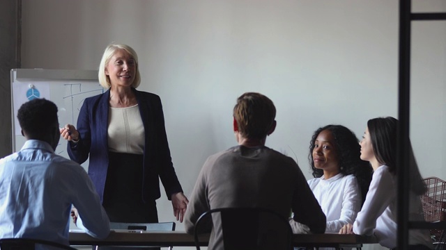 年长的女企业家导师在办公室培训中提供业务演示视频素材