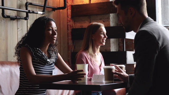 非洲女人和白人男人朋友在咖啡馆的桌子上聊天视频下载