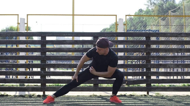 在阳光明媚的早晨，穿着橙色鞋的男性在健身训练前伸展身体视频下载