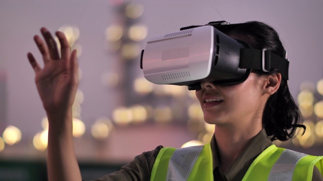 女工程师晚上在石油工厂戴着虚拟现实耳机视频素材