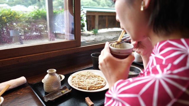 年轻女子在浴田吃日本荞麦面午餐视频素材