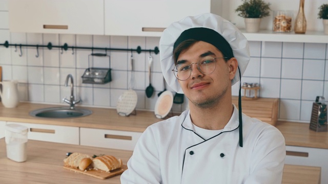 厨师微笑着看着镜头。厨房里的面包师又高兴又高兴。视频素材