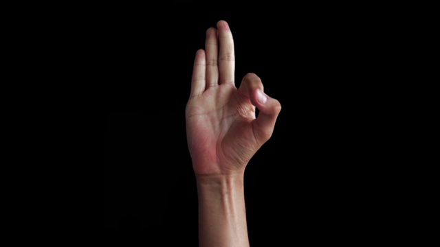 白人白人的手的特写镜头孤立的黑人出现，并显示f字母手语(美国手语)。视频下载