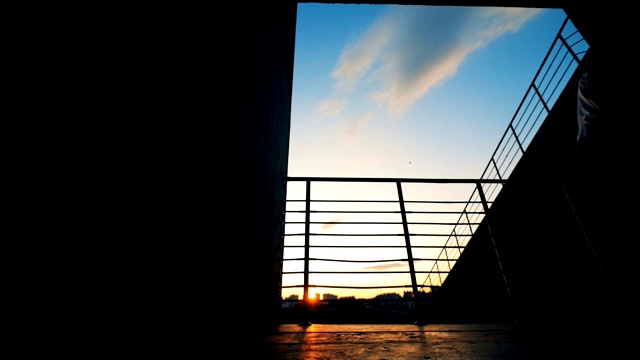 一个人在日落背景下骑着一块板，慢镜头。视频素材