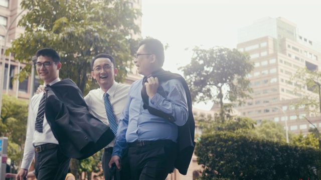 三个快乐的亚洲商人在街上走着笑着视频下载