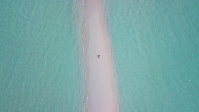 一对年轻的成年夫妇一起躺在马尔代夫碧绿的沙滩上视频下载