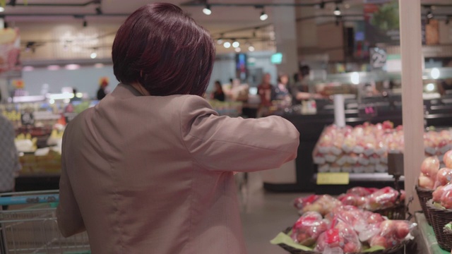 女人选择在超市买水果。视频素材
