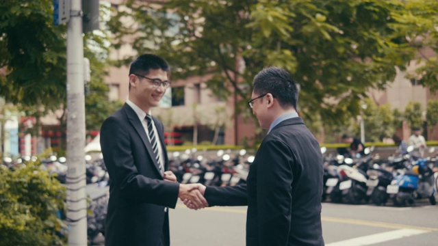 两个亚洲商人在街上交换名片视频素材