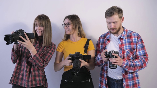 专业摄影师在摄影学校的工作坊学习数码相机的技术规格视频下载