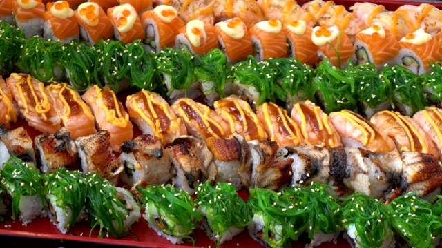 许多寿司卷的特写设置在传统的日本红色托盘背景在餐厅视频素材