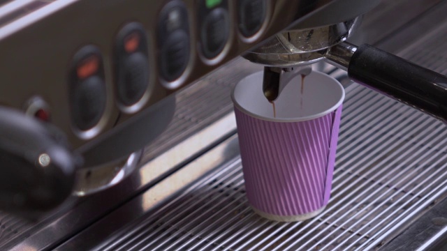 咖啡机在纸杯里制作双倍浓缩咖啡。视频下载