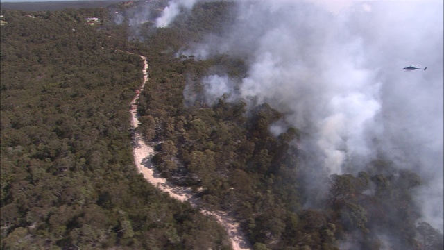 一架直升机飞过澳大利亚墨尔本附近的森林大火。视频下载