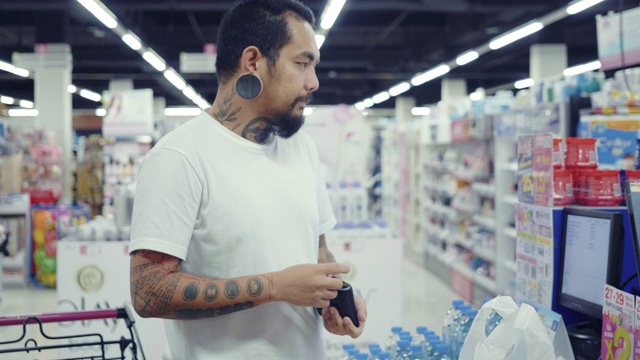 时髦的亚洲男人在超市用现金付款视频素材