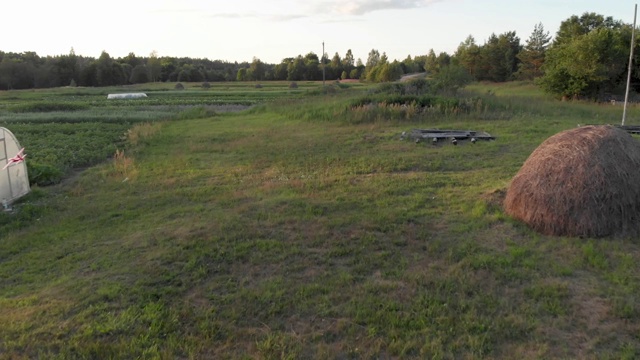 一个穿着粉色连帽衫的小女孩跑着，在日落时分的干草堆附近发射一架滑翔机视频下载