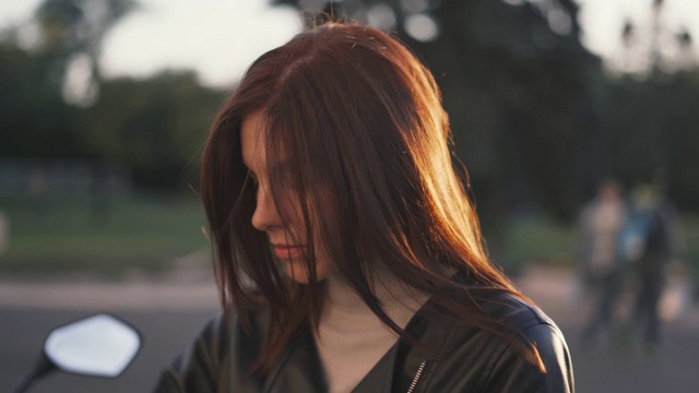 年轻漂亮的红发女摩托车手戴上黑色的摩托车头盔视频下载