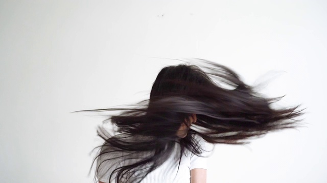 4k慢镜头，一个亚洲女人在摇头发。视频素材