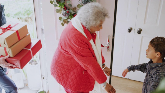 在圣诞节，兴奋的孙子孙女们用礼物问候来访的祖父母视频素材
