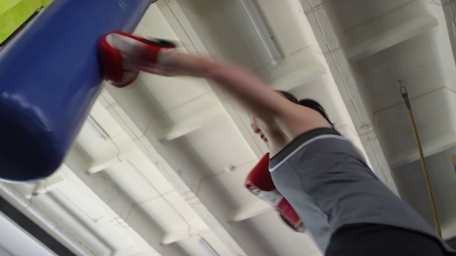 精力充沛的女运动员拳击锻炼期间沉重的袋子视频下载