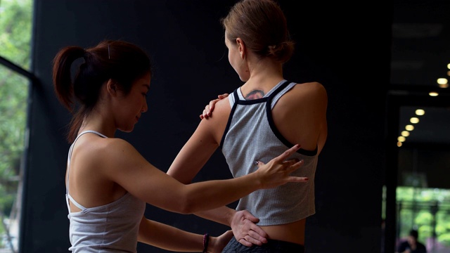 亚洲运动女性和白种白人训练瑜伽在瑜伽工作室教练，开放的光来自自然。健康、城市生活方式理念。慢动作镜头。视频素材