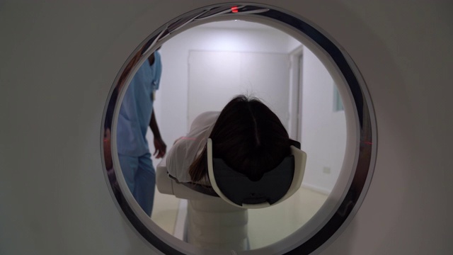 友善的放射科医生正在给一位女性病人做脑部扫描视频下载