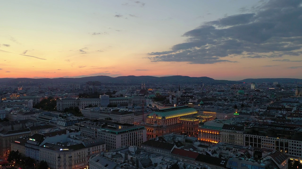 日落时分照明飞行在维也纳市中心歌剧院空中全景4k奥地利视频下载