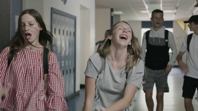 美国犹他州普罗沃，一个傻乎乎的女孩在学校走廊里唱歌跳舞的镜头视频素材