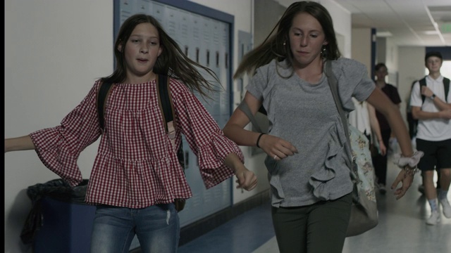 慢动作跟踪拍摄傻女孩唱歌和跳舞在学校走廊/普罗沃，犹他州，美国视频素材