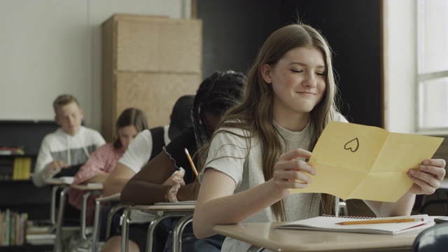 美国犹他州普罗沃，一名男孩在学校教室里向一名女孩传递情书视频下载