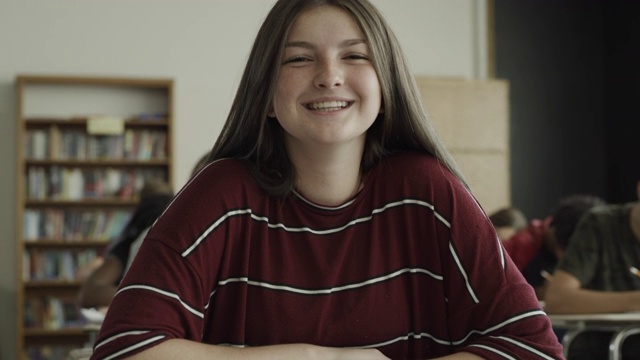 慢镜头摇摄微笑女孩在学校教室的肖像/普罗沃，犹他州，美国视频素材