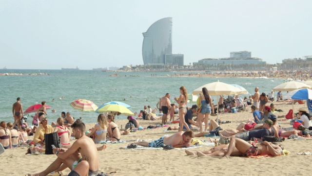 西班牙巴塞罗那海滩的标志性图像。W酒店的背景。人们在巴塞罗那享受阳光明媚的一天视频下载