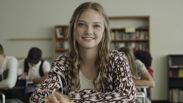 慢镜头摇摄微笑女孩在学校教室的肖像/普罗沃，犹他州，美国视频素材