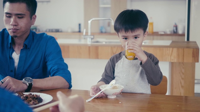 亚洲小男孩吃米饭和喝果汁视频素材