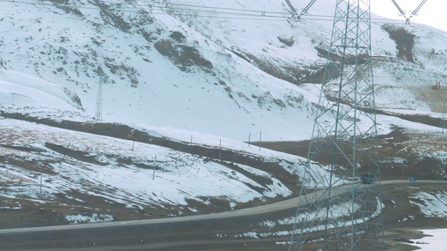 慢镜头:货车行驶在乡村公路上，经过雪山。视频购买