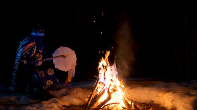 萨满坐在火边敲着鼓。视频下载