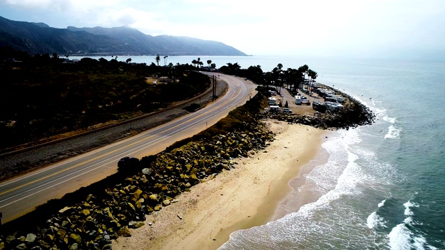 倒车超过海滩戏剧性的高对比度照明加州海岸无人机视图视频素材
