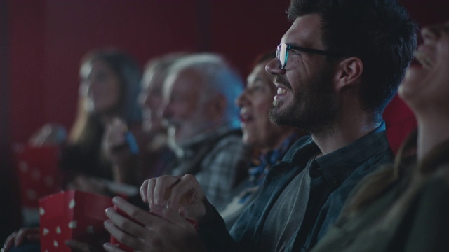 微笑的男人在电影院看电影视频素材