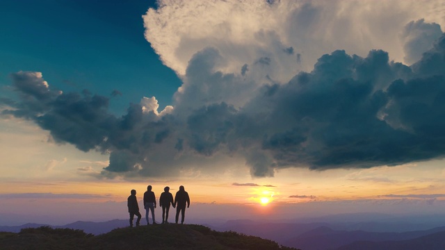 四个人站在山上，面对美丽的日出视频素材