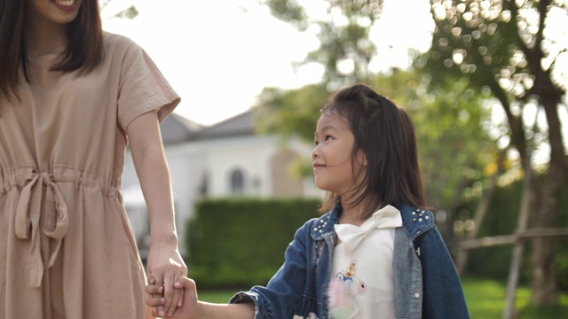 亚洲母亲和女儿牵手走在夏天的一天视频素材