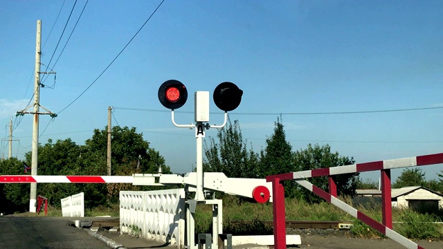 铁路十字路口红灯闪烁，路障降低。视频素材