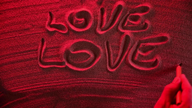 男人的手在沙滩上写着两次爱情。视频下载