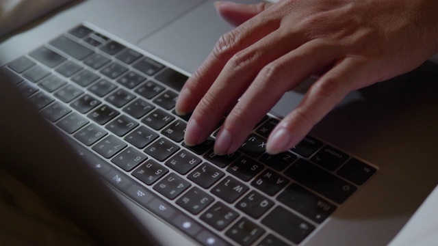 一个男人在晚上使用笔记本电脑。视频下载