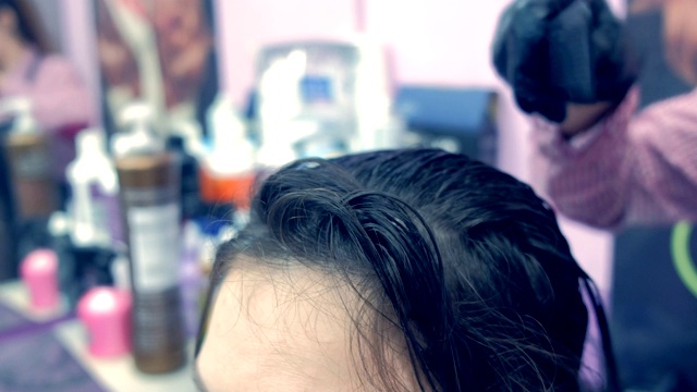 用刷子将角蛋白涂抹在头发上。视频素材