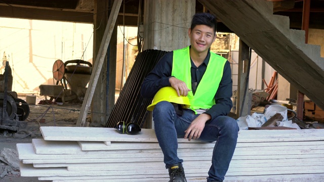 微笑的年轻建筑承包商坐在木板上视频素材