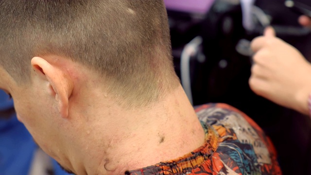 理发师用一把锋利的剃刀刮男人脖子上的毛发。视频下载