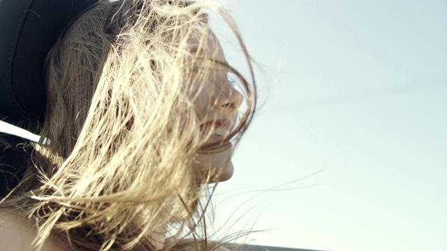 年轻女子坐在敞篷车里，头发在风中飘动视频下载